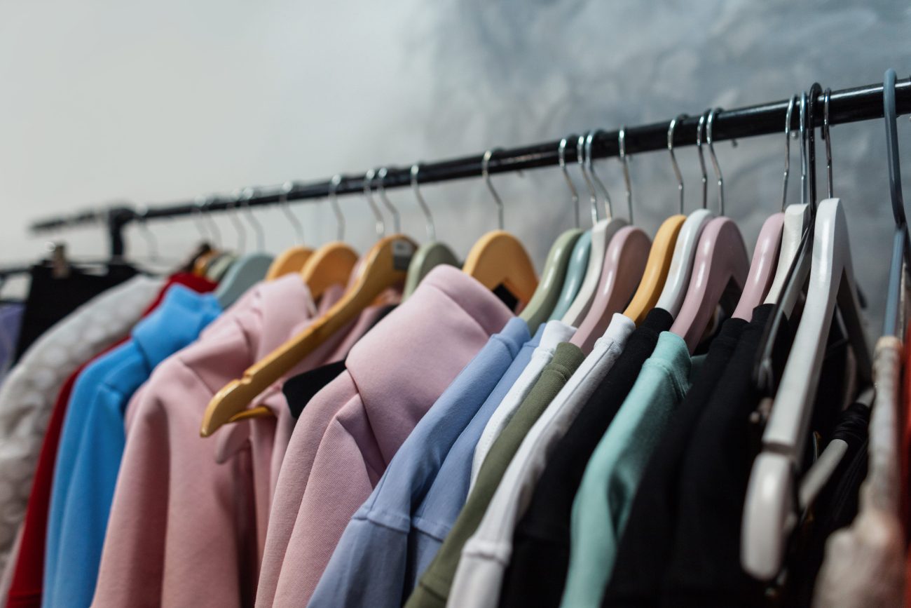 Row of pastel-colored jackets on hangers along a clothing rack in a store