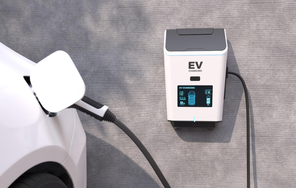 780817 - Electro Alai - Diario a pie de barrio Electric vehicle charging station mounted on a wall with a car plugged in and charging cable connected to the vehicle